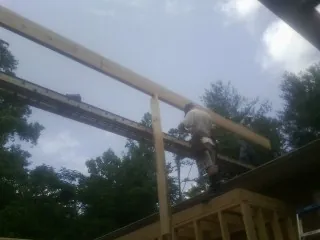 Carpenter setting a ridge beam over a new addition frame — Ice Dam Removal by Roofing Brothers in Reagan