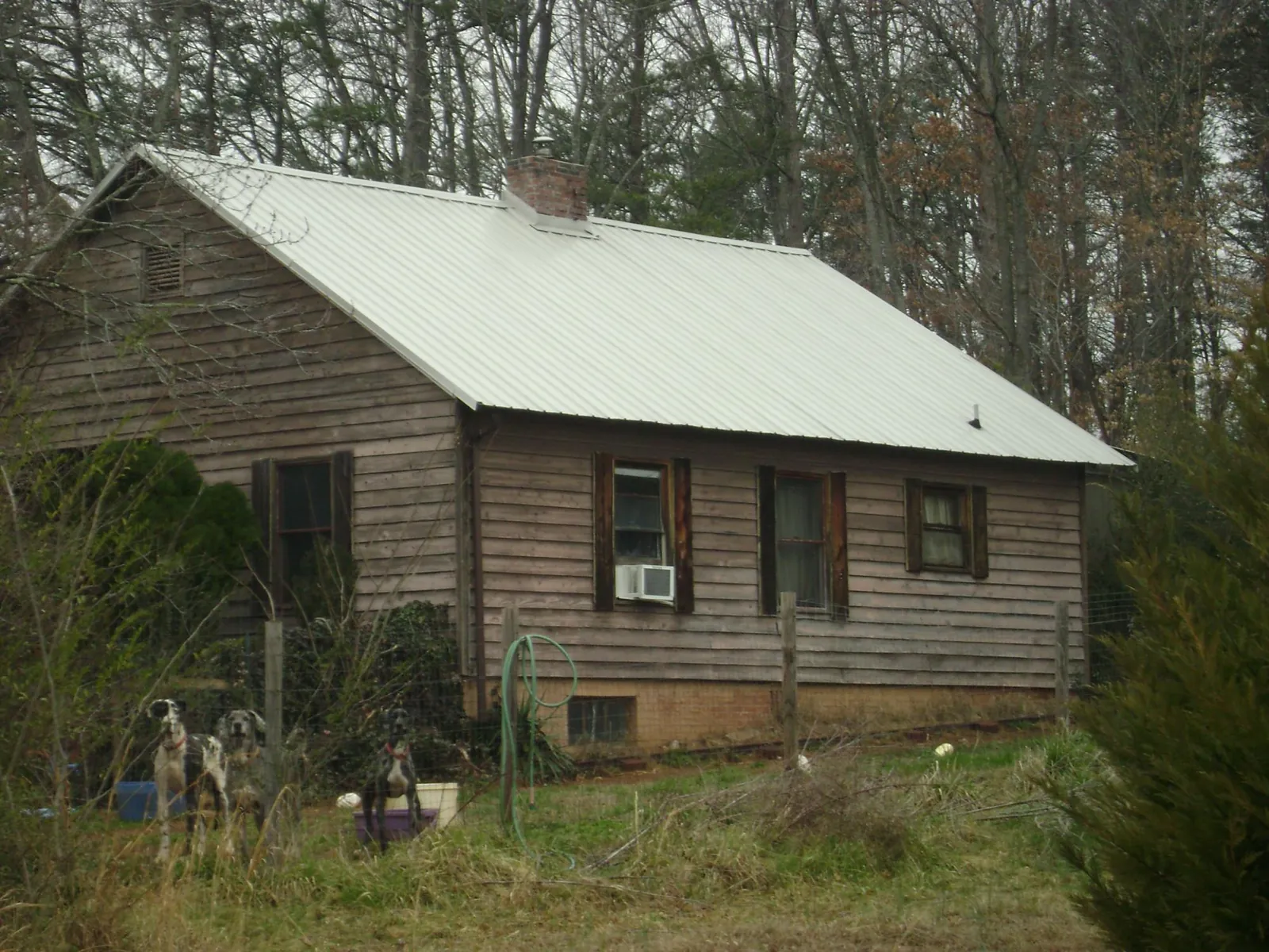 White metal roof on an old wood sided farmhouse, from a Metal Roof Installation job in Reagan